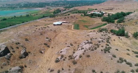 The drone flies over the hills, including a small town on the shores of a Stock Footage 246027624