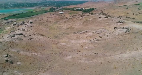 The drone flies over the hills, including a small town on the shores of a Stock Footage 255871198