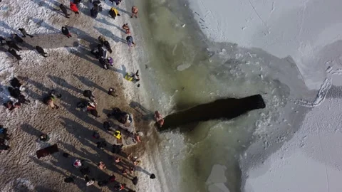 Drone flies over the hole in the winter river, people enter the cold water, Stock Footage 222062239