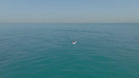 A drone flies over a man sailing on an electric foil board on the open sea next Stock Footage 250752197