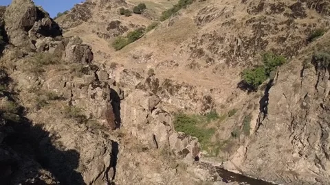 The drone flies over a mountain canyon with a river. A sunny summer day. Stock Footage 278346523