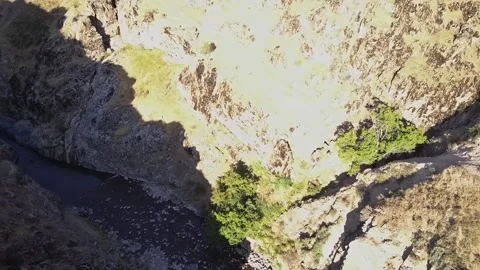 The drone flies over a mountain canyon with a river. A sunny summer day. Video stock 334611343
