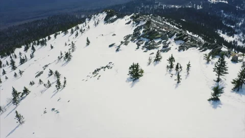 Drone flies over mountain ridge, blue cloudy sky and snow covered slopes Stock Footage 166114505