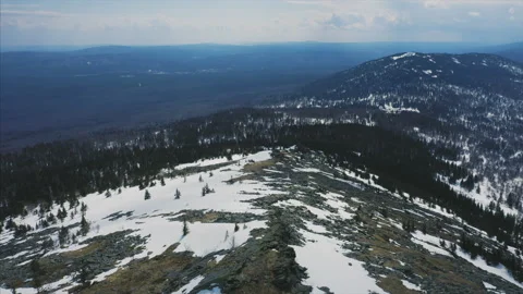Drone flies over mountain ridge, blue cloudy sky and snow covered slopes Stock Footage 166114748