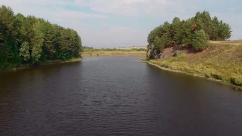 The drone flies over a mountain river, low above the water, along the banks of Stock Footage 162849100