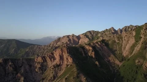 A drone flies over mountains covered with greenery on a sunny spring day Stock Footage 334606315