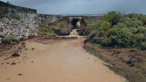 A drone flies over mud-covered mountain river flowing into the sea. Stock Footage 146822105