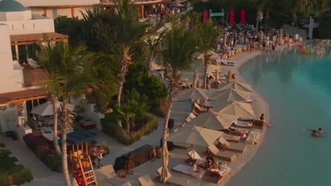 A drone flies over an outdoor pool with a club by the sea, Dubai. People Stock Footage 254787518