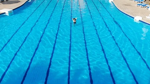 Drone flies over a pool in Egypt, where a woman swims on a mattress Stock Footage 129088611