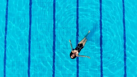 Drone flies over a pool in Egypt, where a woman swims on a mattress 스톡 동영상 129092824
