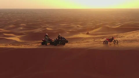 A drone flies over quad bikes driving through the sand dunes of the desert in Stock Footage 244769407