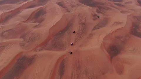 A drone flies over quad bikes driving through the sand dunes of the desert in Stock Footage 246501018