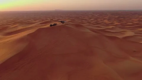 A drone flies over quad bikes driving through the sand dunes of the desert in Stock Footage 254695932