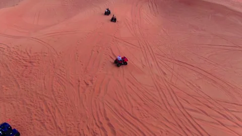 A drone flies over quad bikes driving through the sand dunes of the desert in Stock Footage 270212163