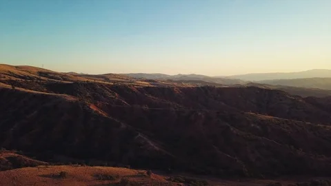 Drone flies over red mountains on sunset. Raw footage included with the color gr Video stock 90983509