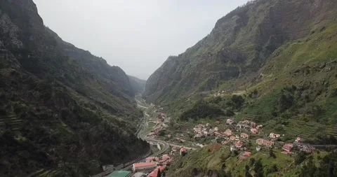 Drone flies over red tiled rooftops, mountain valley in Madeira Clip 3 Stock Footage 140623248