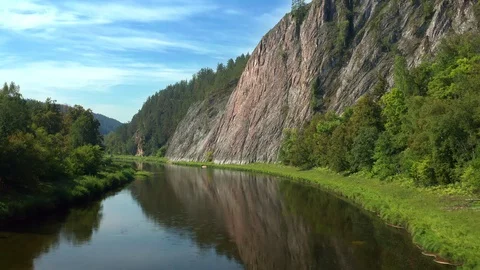 A drone flies over a river along a mountain range. Stock Footage 114727863