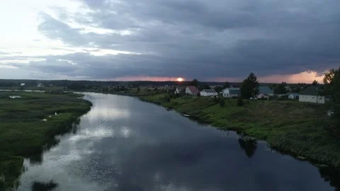 The drone flies over the river along the banks of which are the houses of a Stock Footage 169583296