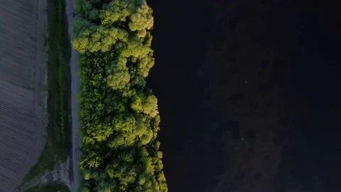 The drone flies over the river and the forest through which the road goes Stock Footage 155884824