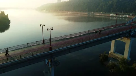 Drone flies over the river, haze and fog. people are walking on the bridge Stock Footage 185575357