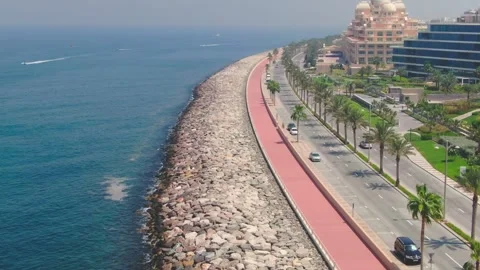 A drone flies over a road along the seashore near Dubai, United Arab Emirates Stock Footage 242917993