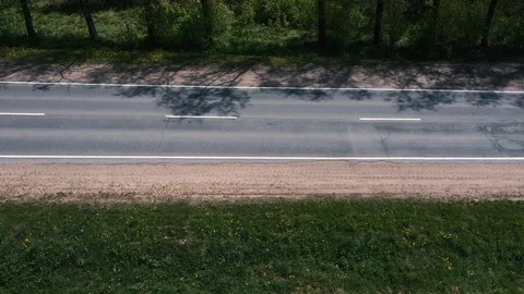 The drone flies over the road between the trees and watching the cars Vídeos de archivo 107926888