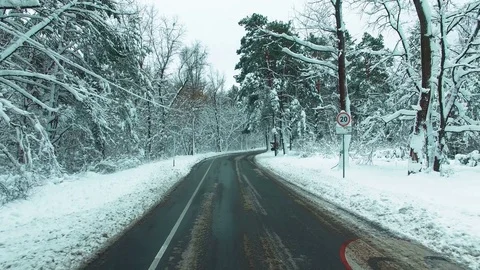 Drone flies over the road through the winter snow forest . Car POV. Stock Footage 83749748