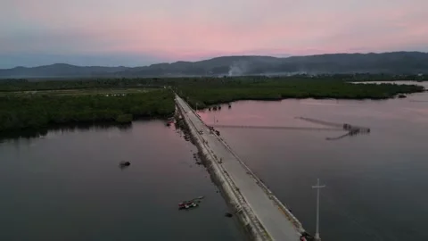 The drone flies over the road on which mopeds ride, the road passing through the Stock Footage 227993006
