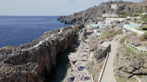 Drone flies over the rocks and Kalypso beach village. Volcanic archipelago Stock Footage 168250526