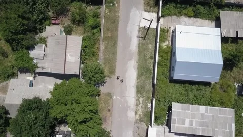 The drone flies over the roofs of one-story houses. A sunny summer day. Stock Footage 278346228