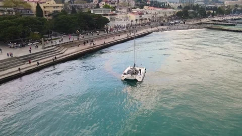 A drone flies over a sailing catamaran in the bay of Yalta, Crimea. Stock Footage 254334292