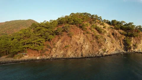 Drone flies over the sea and rises above the rocky coast Video stock 256020719