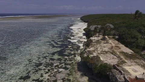 Drone flies over shallow tide pools next to entrance to beach Stock Footage 344047181