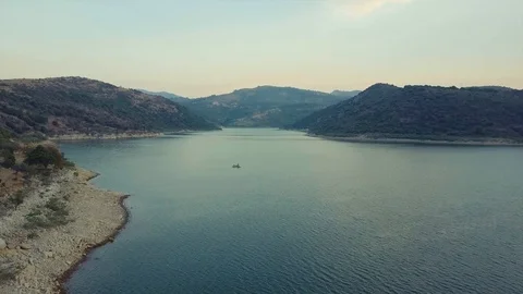 Drone flies over a single little boat on a lake at sunset. Stock Footage 90986151