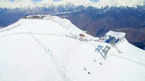 Drone flies over  ski station on top of  mountain to snow-covered ridge 스톡 동영상 84732936