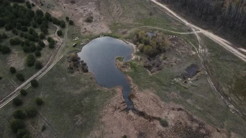 Drone flies over a small lake located in the forest 4k footage Stockbeeldmateriaal 162257985