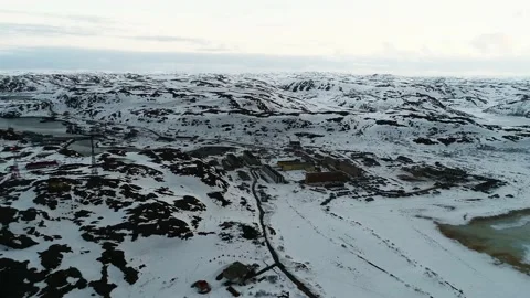 The drone flies over a small northern town surrounded by snow-covered cliffs Stock Footage 169464086