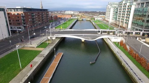 Drone flies over a small river in Dublin while trams cross the bridge, Ireland Video stock 114582896