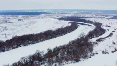 Drone flies over the snowy flat landscape with a frozen river. Beautiful na.. Stock Footage 229777931