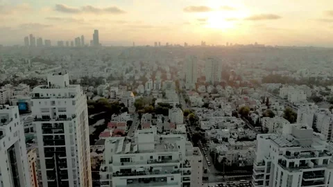 A drone flies over tall buildings at dawn. Holon city israel Stock Footage