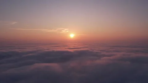 A drone flies over thick fog, showing a beautiful sea of clouds at sunrise, as t Stock Footage 299002203