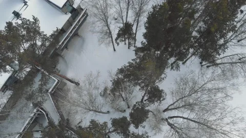 The drone flies over the treetops under which a winter hunting lodge is hidden Stock-Footage 151638165