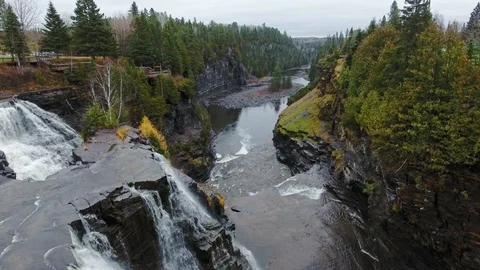 Drone flies over a waterfall, cliffs, autumn forest and shallow water Video stock 126080754