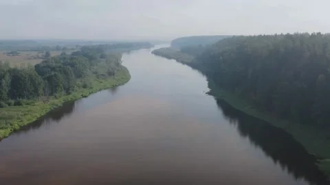 Drone flies over a wide river through green forest Stock-Footage 333836457