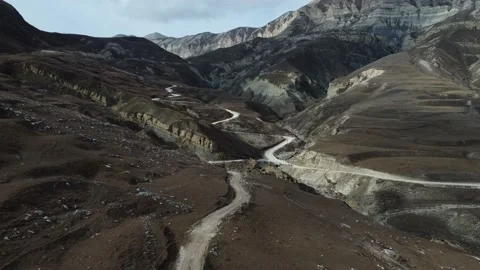 A drone flies over winding mountain road Stock Footage 195199516
