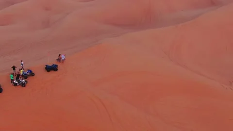 Drone flies over a young couple standing on a sand dune in the desert of the Stock Footage 240949988