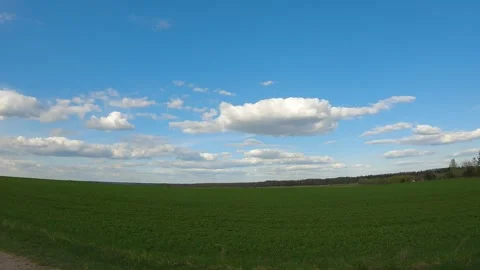 The drone flies parallel to the ground, along a green field. Blue sky Stock-Footage 252299385