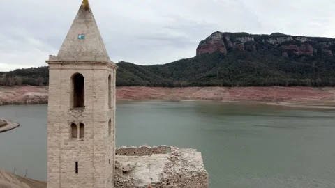 Drone flies past the bell tower of abandoned church towards an empty reservoir Stock Footage 285446740