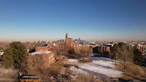 Drone flies past Brick Building towards Downtown Denver Colorado in the snow Stock Footage 296466084