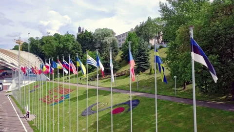 Drone flies past over a large number of country flags in a row fluttering in the Stock Footage 136733136